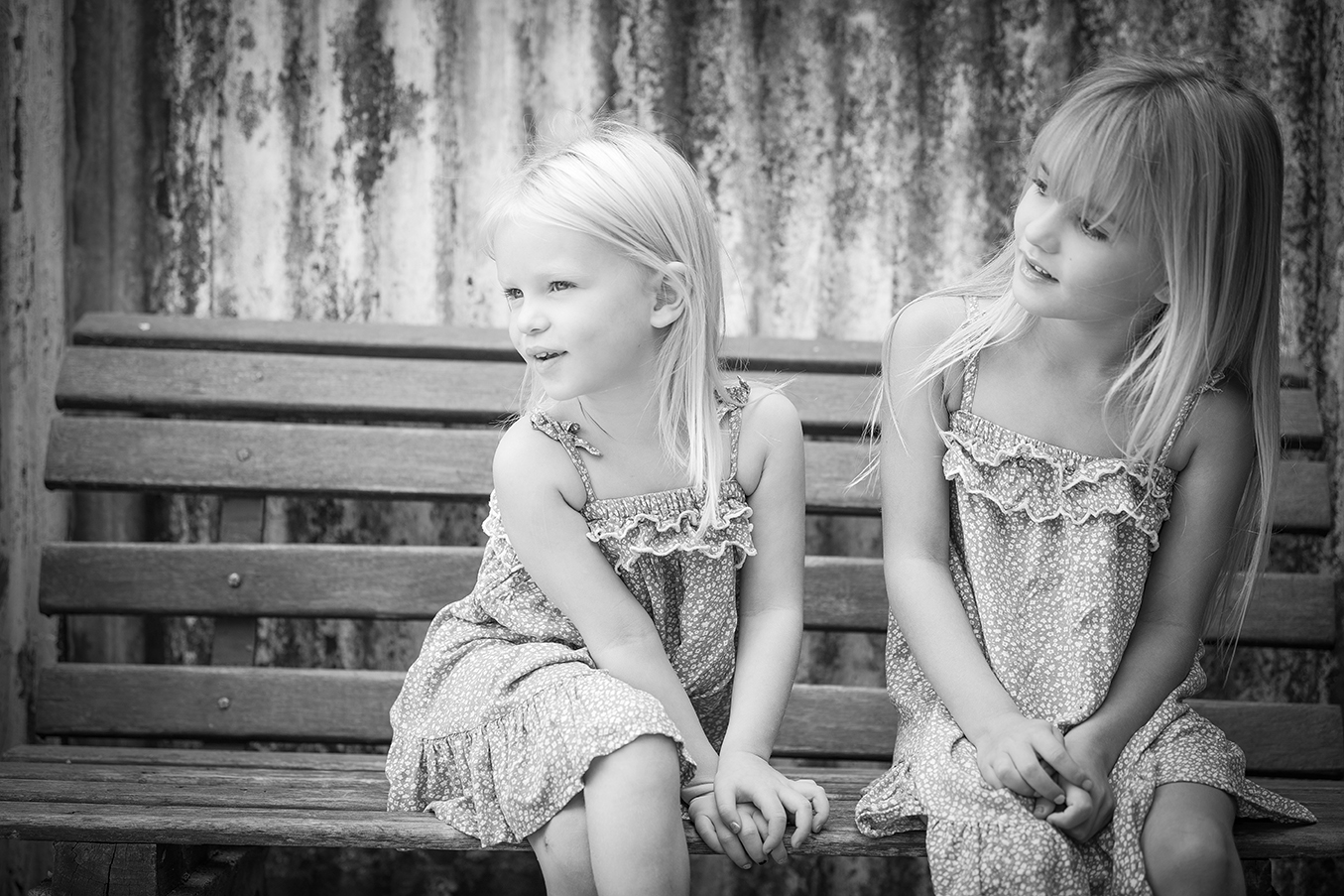 Classic black & white child portrait of sisters, in outdoor setting at photography studio shot by Kevin Mark Pass
